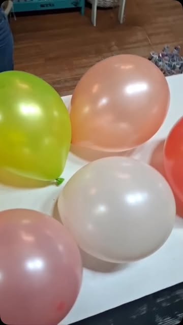 Globos de látex en tonos pastel sobre una mesa blanca